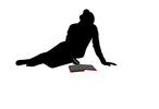 Silhouette einer Lesenden, auf dem Boden sitzend