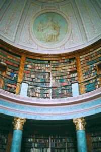 Alte Bibliothek mit Stuckdecke und marmornen Säulen.